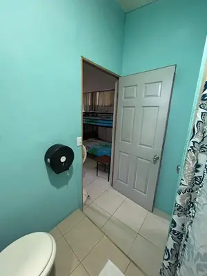 a blue bathroom with a toilet and a door at Blue Morpho House B&B in Manuel Antonio