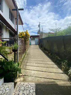 a walkway leading to a building with a fence at Blue Morpho House B&B in Manuel Antonio