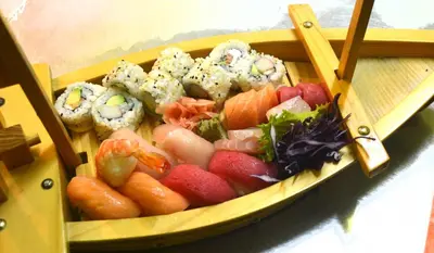 a tray of sushi and vegetables on a table at Hotel Columbus in San José