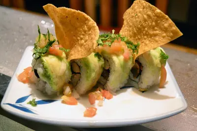 a plate of sushi with tortilla chips and vegetables at Hotel Columbus in San José