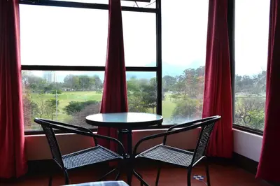 a table and two chairs in a room with windows at Hotel Columbus in San José