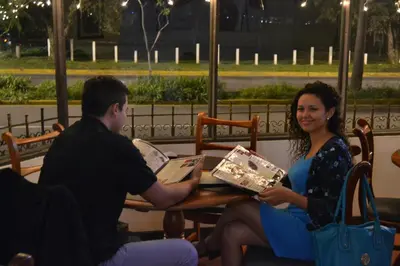 a man and woman sitting at a table with a box at Hotel Columbus in San José