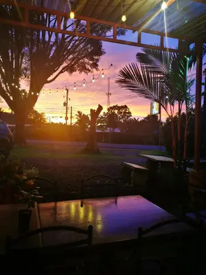 a sunset over a patio with a table and trees at Hotel Vale's in Chiles