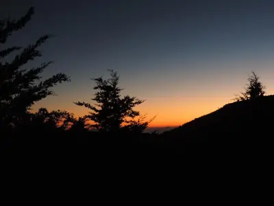 a sunset on a mountain with trees in the foreground at Quinta Galeon Lodge in Santa María