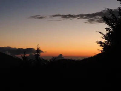 a sunset in the mountains with trees in the foreground at Quinta Galeon Lodge in Santa María