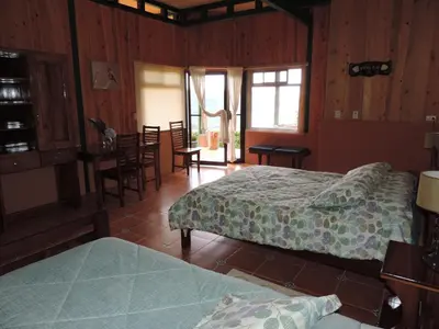 a bedroom with two beds and a table and chairs at Quinta Galeon Lodge in Santa María