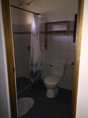 a small bathroom with a toilet and a shower at Cabinas Lindo Horizonte in San Pedro