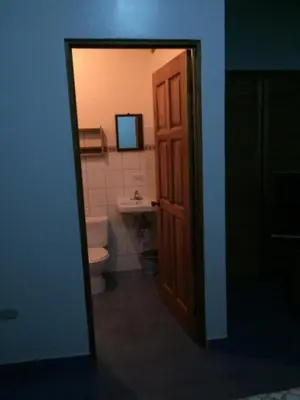 a bathroom with a toilet and a sink and a door at Cabinas Lindo Horizonte in San Pedro