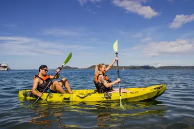 two people in a yellow kayak in the water at Papagayo Golden Palms Beachfront Hotel in Papagayo, Guanacaste