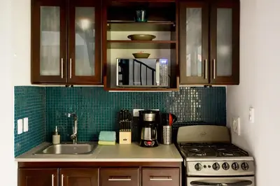 a kitchen with a sink and a stove and cabinets at Tico Tico Villas - Adult Only in Manuel Antonio
