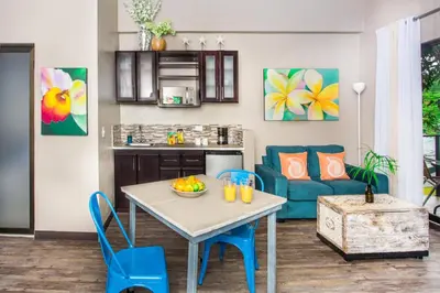 a kitchen and living room with a table and chairs at Tico Tico Villas - Adult Only in Manuel Antonio