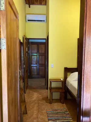 a hallway with a room with a bed and a door at Tico Adventure Lodge in Sámara