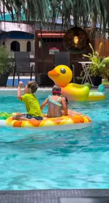 two boys riding on a raft in a pool at CLUB IBIZA - Party Hotel & Beach Club in Jacó