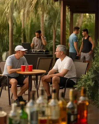 two men sitting at a table in a patio at CLUB IBIZA - Party Hotel & Beach Club in Jacó