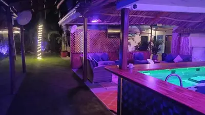 a nightclub with a swimming pool and purple lighting at CLUB IBIZA - Party Hotel & Beach Club in Jacó