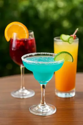 three cocktails sitting on a wooden table at CLUB IBIZA - Party Hotel & Beach Club in Jacó