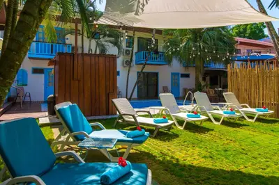 a group of chairs and an umbrella and a pool at CLUB IBIZA - Party Hotel & Beach Club in Jacó