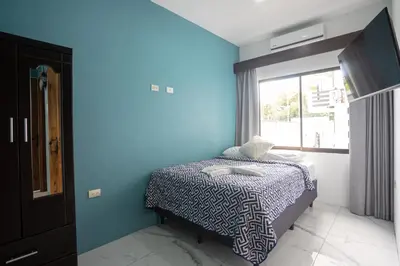 a bedroom with a bed with a blue wall at Inn On The Park in Manuel Antonio