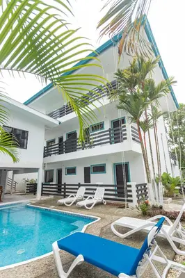 a villa with a swimming pool and palm trees at Inn On The Park in Manuel Antonio