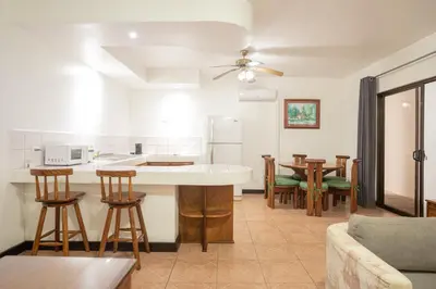 a kitchen and living room with a table and chairs at Inn On The Park in Manuel Antonio