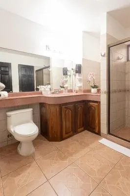 a bathroom with a toilet and a sink and a shower at Inn On The Park in Manuel Antonio