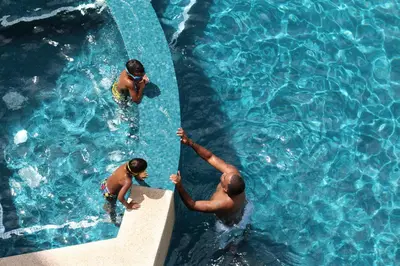 a group of people in a swimming pool at Luxury SKY PENTHOUSES 3-6BR Condo-Hotel at Oceano Jaco in Jacó