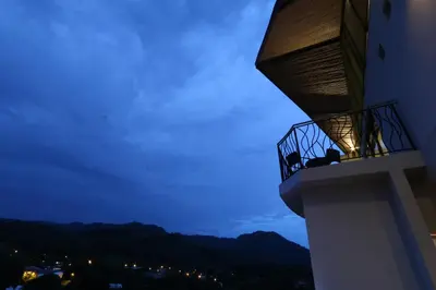 a couple sitting on a balcony of a building at night at Luxury SKY PENTHOUSES 3-6BR Condo-Hotel at Oceano Jaco in Jacó