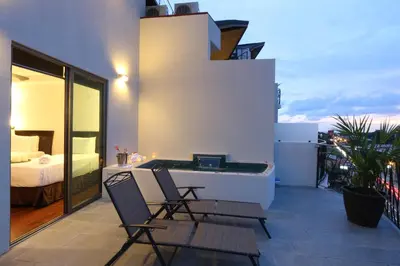 a balcony with two chairs and a bed on a building at Luxury SKY PENTHOUSES 3-6BR Condo-Hotel at Oceano Jaco in Jacó
