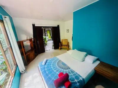 a bedroom with a bed with two red pillows on it at Guest House Pura Vida in Quepos