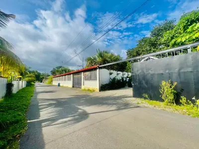 an empty road with a fence and a building at Guest House Pura Vida in Quepos