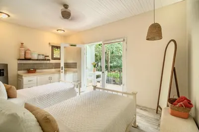 two beds in a room with a window at Hotel Casa Leona in Tamarindo