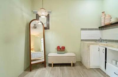 a bathroom with a mirror and a stool and a sink at Hotel Casa Leona in Tamarindo