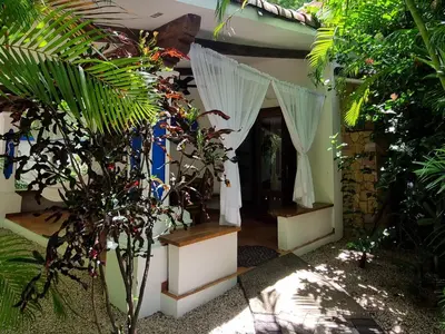 a garden entrance to a house with curtains and plants at Villas Kalimba in Sámara