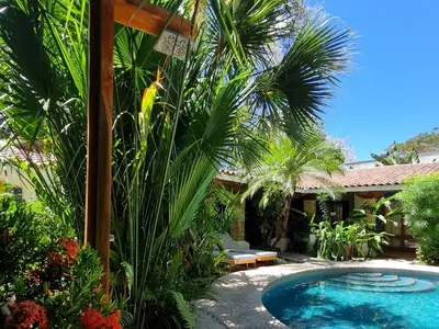 a pool in a yard with palm trees and a house at Villas Kalimba in Sámara