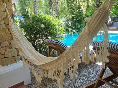 a hammock on a patio next to a pool at Villas Kalimba in Sámara
