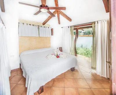 a bedroom with a bed and a ceiling fan at Villas Kalimba in Sámara
