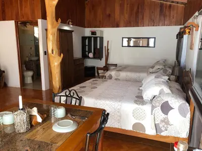 a bedroom with a bed and a wooden table at Casa Haydee Monteverde in Monteverde Costa Rica