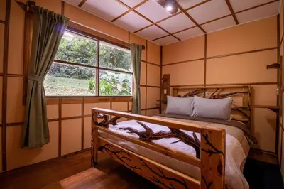 a bedroom with a wooden bed and a window at Forest Garden House in Monteverde Costa Rica