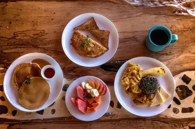 a table with plates of food and a cup of coffee at Forest Garden House in Monteverde Costa Rica