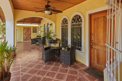 a dining room with a ceiling fan and a table and chairs at Casa Amarilla in Esterillos