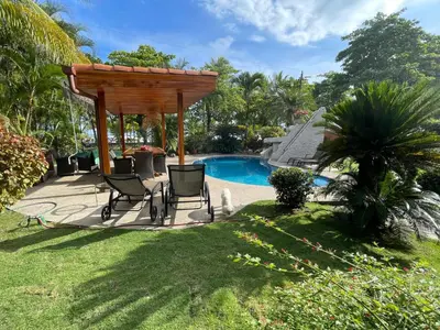 a patio with a gazebo next to a pool at Casa Amarilla in Esterillos