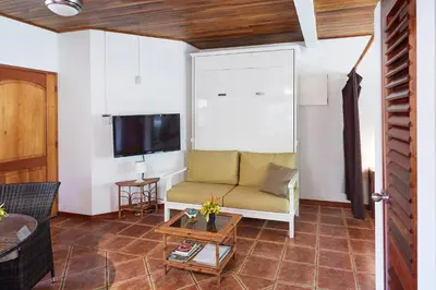a living room with a couch and a tv at Casa Amarilla in Esterillos