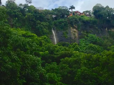 a waterfall on the side of a hill with trees at Montezuma Heights in Montezuma