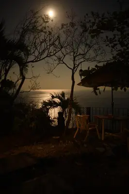 a table and chairs in front of the ocean at night at Montezuma Heights in Montezuma