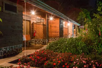 a house with flowers in front of it at night at Savegre Hotel Natural Reserve & Spa in San Gerardo de Dota