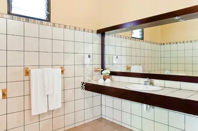 a bathroom with a sink and a mirror and towels at Savegre Hotel Natural Reserve & Spa in San Gerardo de Dota