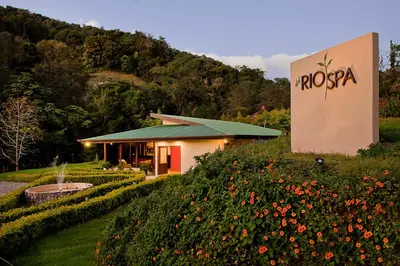 a hotel with a sign in front of a field of flowers at Savegre Hotel Natural Reserve & Spa in San Gerardo de Dota