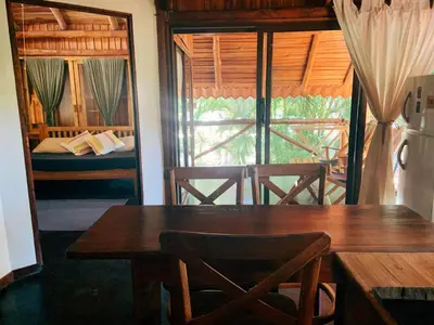 a dining room with a table and a bed and a window at Griss Lodge & Spa in Santa Teresa Beach