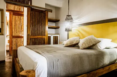 a bedroom with a large bed with white sheets and pillows at Griss Lodge & Spa in Santa Teresa Beach