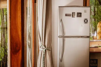 a white refrigerator in a kitchen next to a window at Griss Lodge & Spa in Santa Teresa Beach